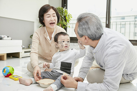 爷爷奶奶陪孙子在客厅玩耍图片