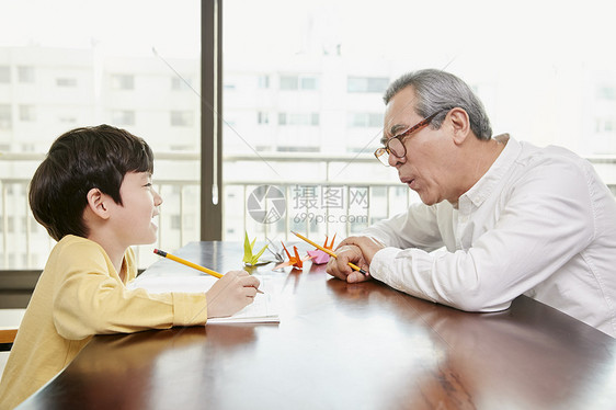 爷爷看着小男孩写字图片