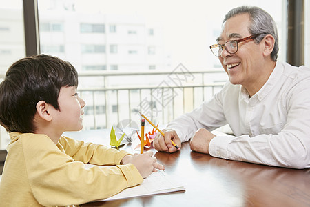 爷爷看着小男孩写字图片