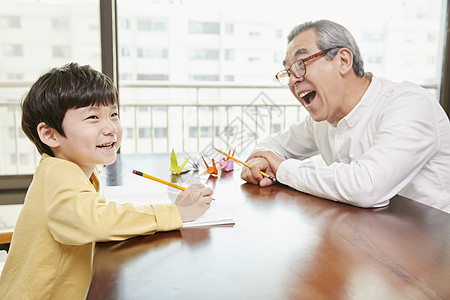 爷爷看着小男孩写字图片