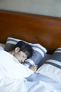 在床上睡觉的男性图片