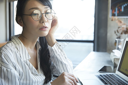 戴着眼镜托脸思考的青年女子图片