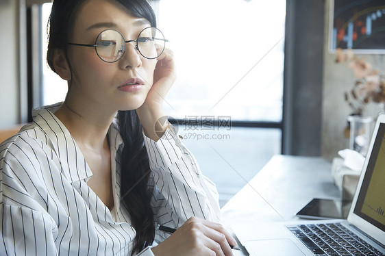 戴着眼镜托脸思考的青年女子图片