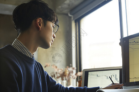 青年男子看着股票交易记录图片