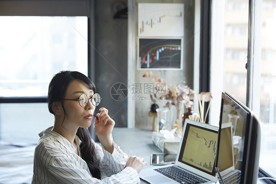 看着股市信息的成年女子图片