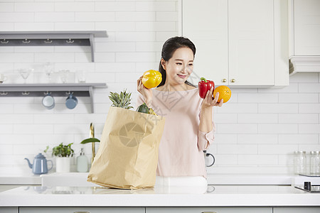 拿着彩椒微笑的女青年图片