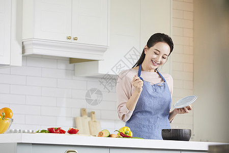 厨房里烹调食物的成年女子图片