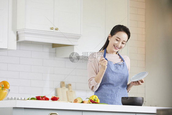 厨房里烹调食物的成年女子图片