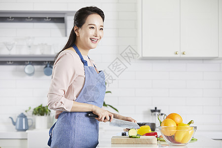 砧板上切菜的成年女子图片