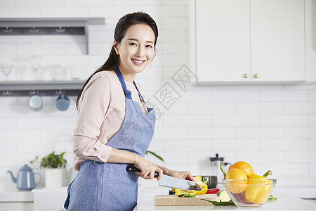 厨房里切菜微笑的成年女子图片