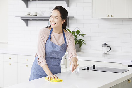 年轻女子拿着抹布清洁桌面图片