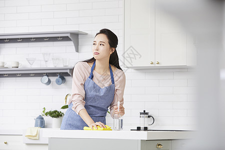 拿着抹布擦拭桌面疲惫的女青年图片