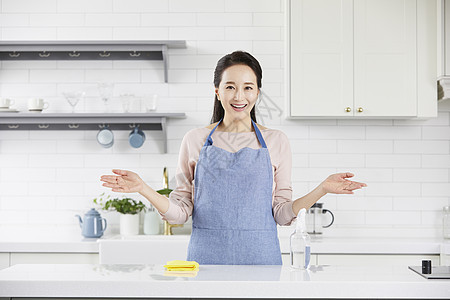 厨房里摊开手微笑的成年女性图片