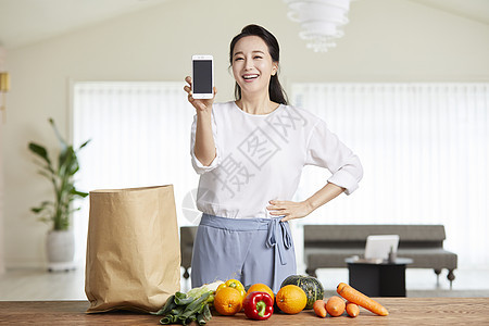 拿着手机微笑的成年女子图片