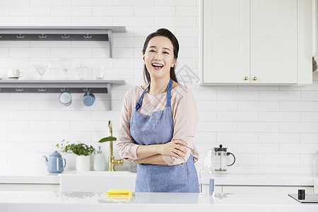 厨房里穿着围裙开心的成年女子图片