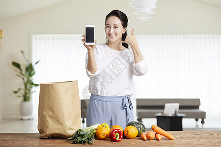 青年女子拿着手机比打电话的手势图片