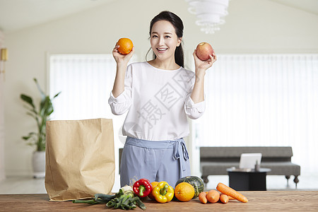 拿着水果开心的成年女子图片