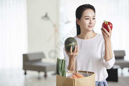 年轻女子看着手上的甜椒图片