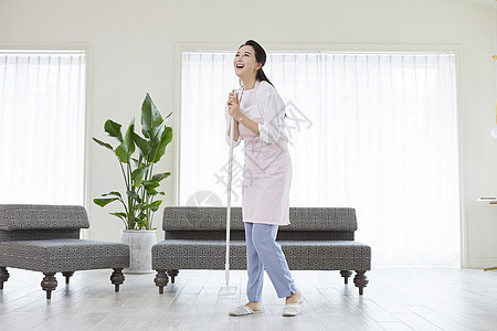 拿着拖布开心的家庭主妇形象图片