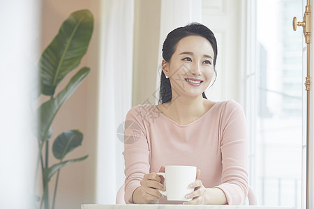 拿着咖啡微笑的成年女子图片