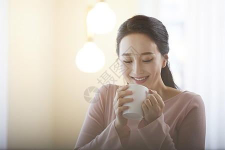 低头喝咖啡的年轻女子图片