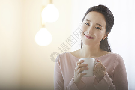 拿着咖啡微笑的气质女性图片