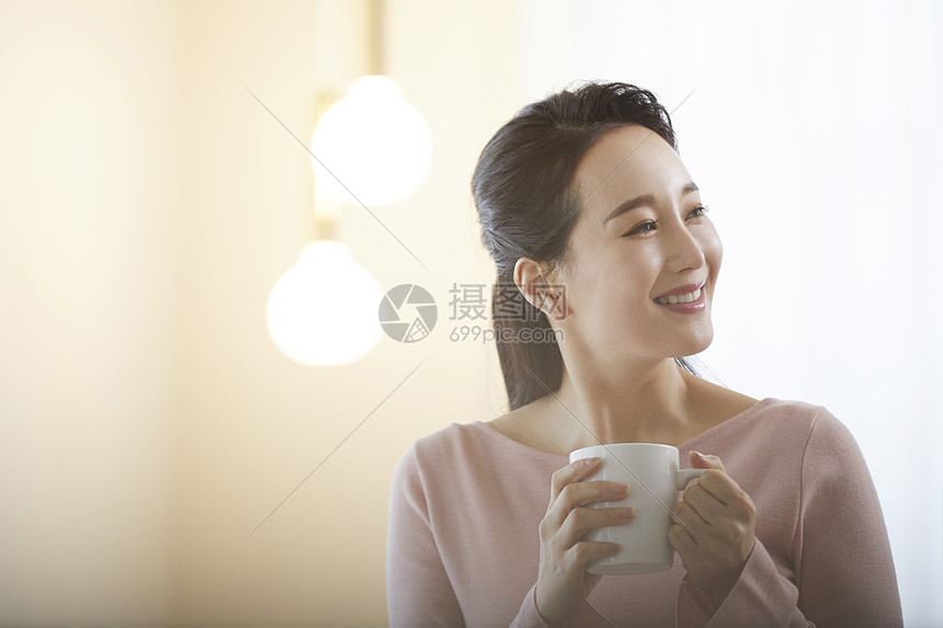 拿着咖啡微笑的女性图片