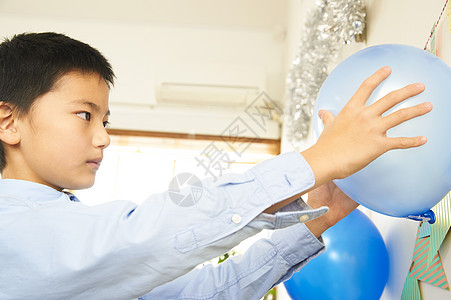 男孩安置生日聚会上的气球高清图片