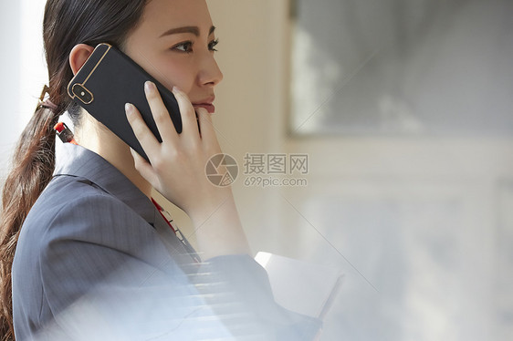 公司女职员在窗边讲电话图片