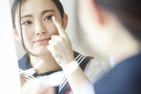 高中女孩照着镜子佩戴美瞳图片