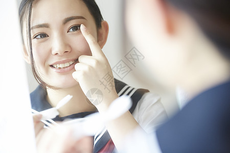 高中女孩照着镜子佩戴美瞳图片