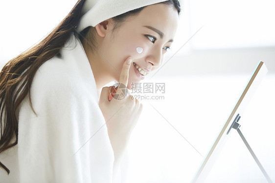 年轻女人涂抹美容护肤品图片