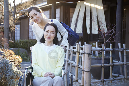 女儿推着轮椅上的妈妈户外散心图片