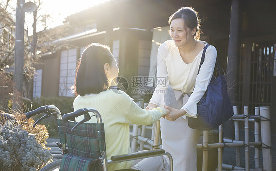 女儿推着轮椅上的妈妈户外散心图片