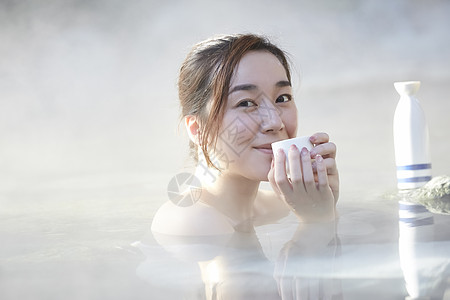 女人露天泡温泉喝清酒图片