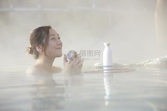 女人露天泡温泉喝清酒图片