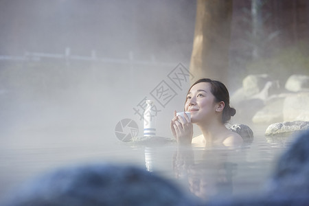 女人露天泡温泉喝清酒图片