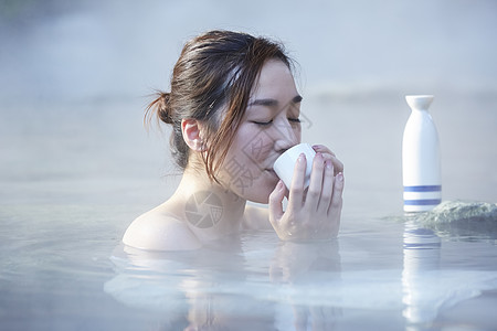 女人露天泡温泉喝清酒图片