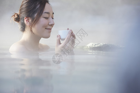 女人露天泡温泉喝茶图片