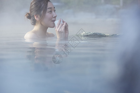 女人露天泡温泉喝茶图片