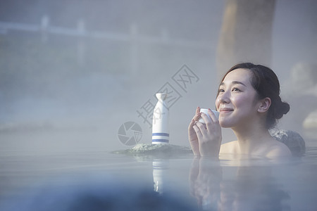 日式浴室泡户外温泉喝清酒的青年女性背景