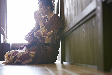 穿着日式浴衣喝茶的年轻女性图片