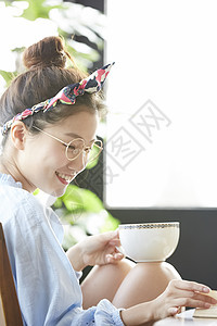 女孩子端着茶杯开心地笑图片