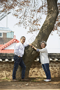 快乐生活的老夫妇在大树边图片