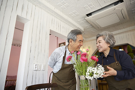 老夫妇戴围裙在室内一起休闲生活图片