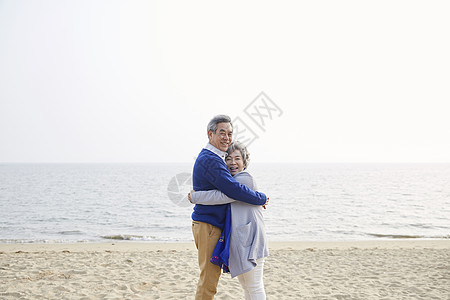 老夫妇在海边相互拥抱一起图片