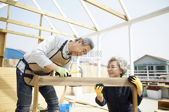 开心的老年夫妇在楼顶一起装修房子图片