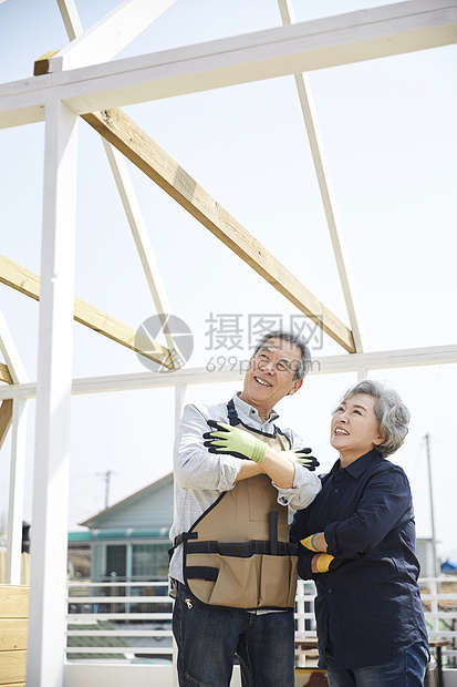 开心的老年夫妇在楼顶一起装修房子图片