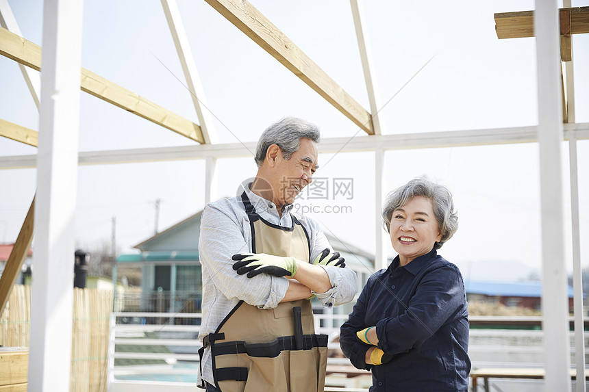 开心的老年夫妇在楼顶一起装修房子图片