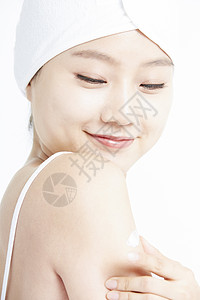 身体护理涂乳霜的年轻女性图片